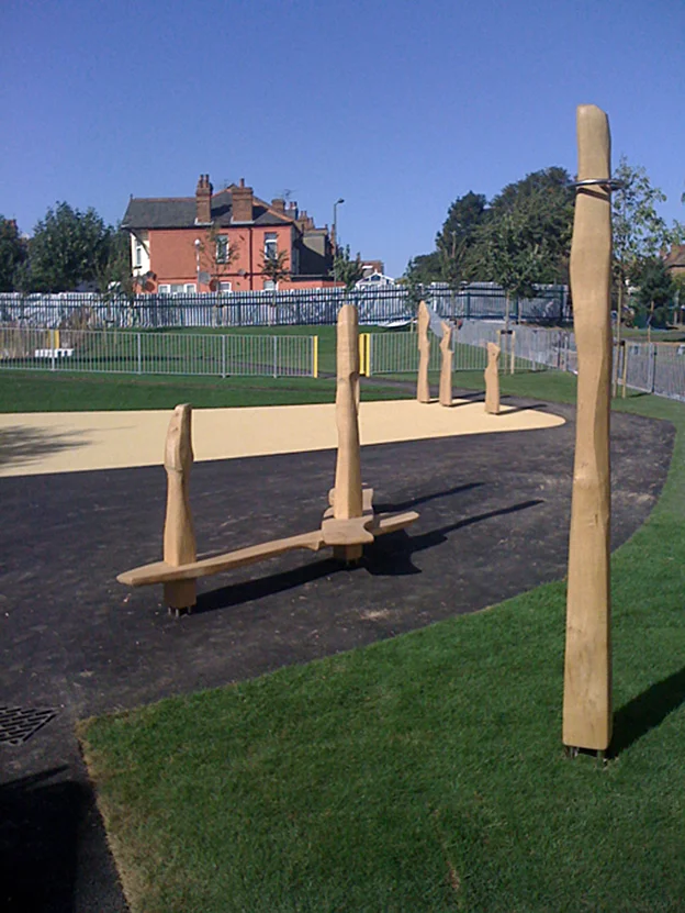 Play area installation including may pole, running bench and shape forms.