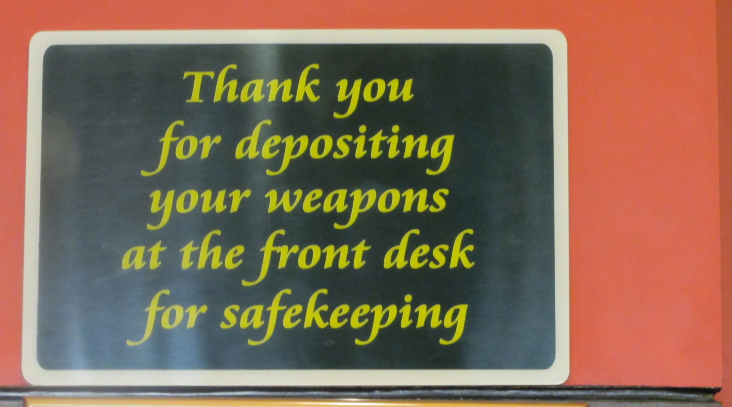 The surprising hotel counter sign: "Thank you for depositing your weapons at the front desk for safekeeping." (Photo by Lisa Suguitan Melnick)
