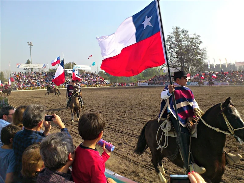 Chilean huasos wave the national flag in a rodeo show during Dieciocho, the country's Independence Day celebrations. (Photo by Migs Bassig)