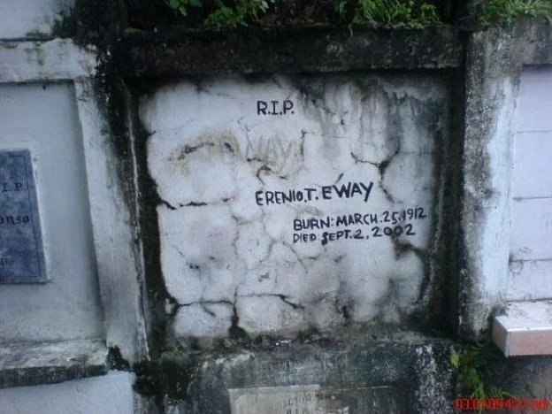 Sign displays: "R.I.P. Erenio. T. Eway. Burn: March 25, 1912. Died Sept. 2, 2002"