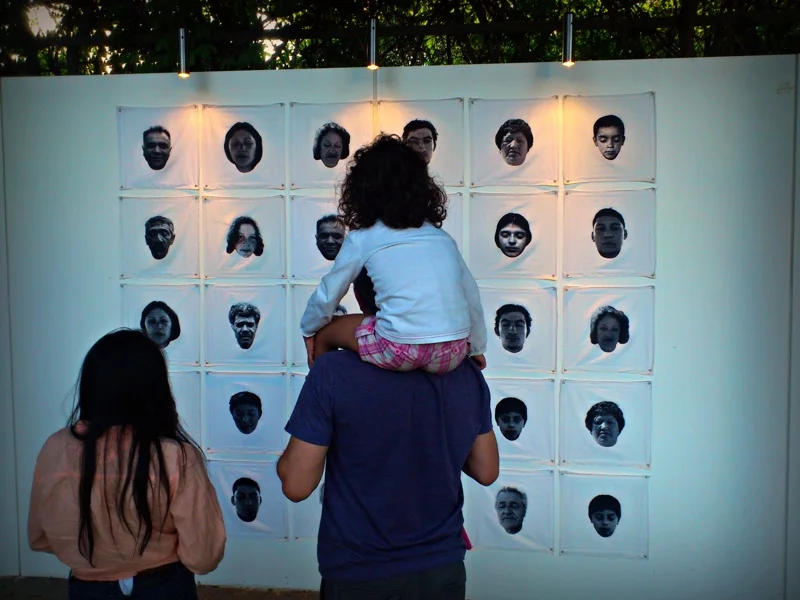 A father and his daughters view one of the installations at a mixed-media art fair in Parque Araucano, Santiago.