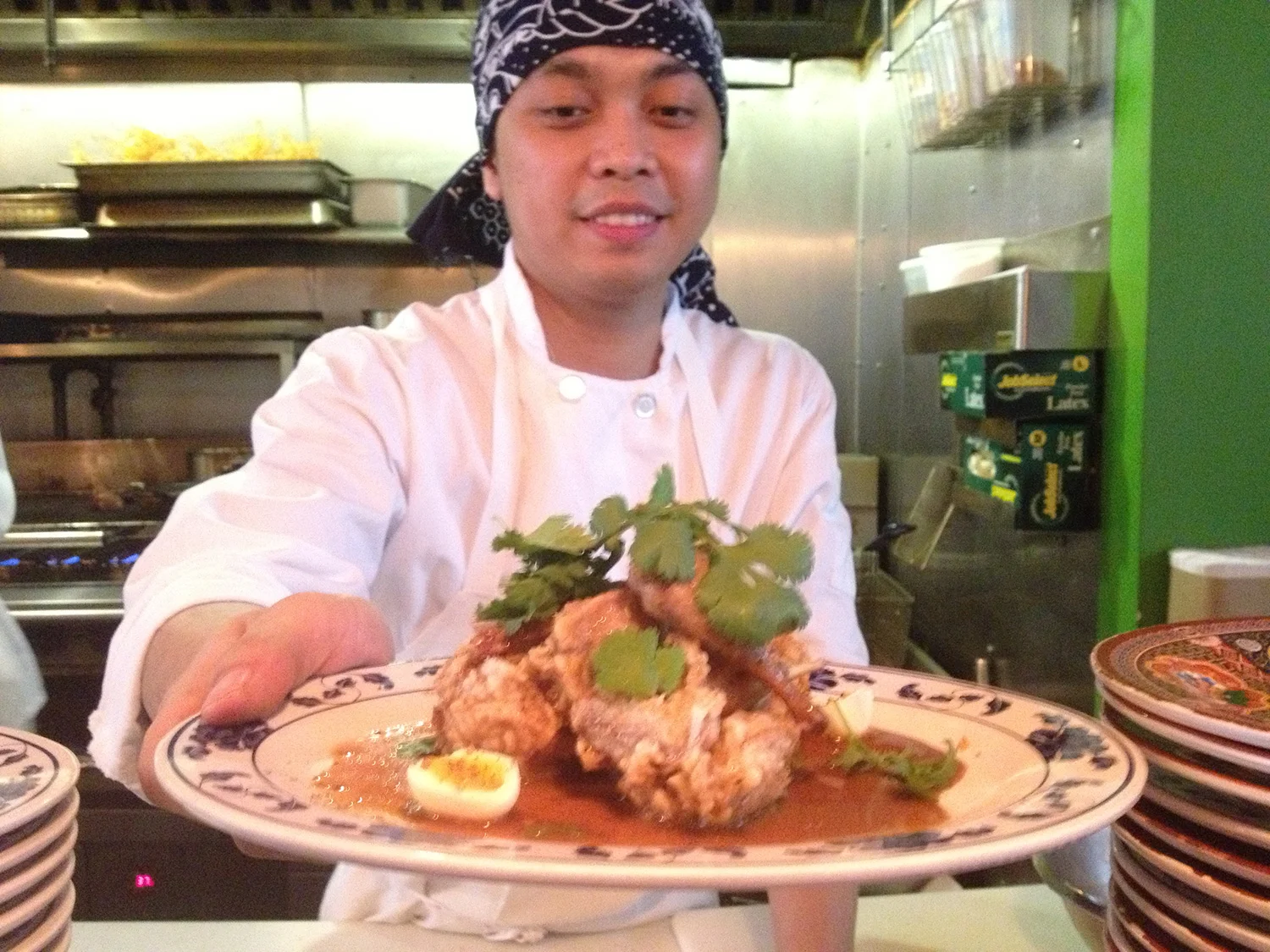 Pig and Khao's Filipino line cook Jesse serves up the Quail Adobo, which is deep fried with soy sauce, vinegar, Szechuan peppercorns and crispy garlic. (Photo by Elizabeth Ann Quirino)
