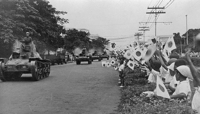 Children waves flags at the Japanese tanks