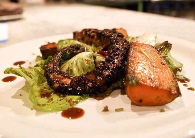 Soy-vinegar braised octopus, coconut oil confit kamote, chicories, and black garlic & cilantro vin (Photo courtesy of LASA Restaurant Project)