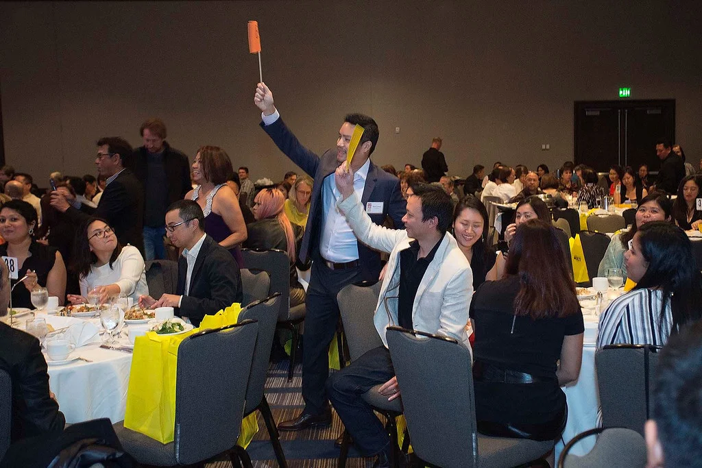Furious bidding from guests at PIA’s 2015 “Giving Hope to the Children II” event for the various generous Live Auction prize packages. This portion raised about $30,000 this year, including 121 new children’s educational pledges. (Photo by Noel Ferrer)