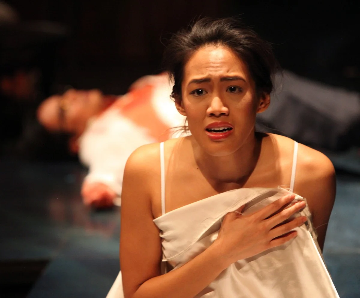 Daisy (Christine Jamlig) wakes to her father’s (Ogie Zulueta) assasination (Photo by Jennifer Reiley).