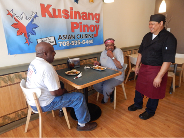 Johnny Ventura chats with customers Tommy and Bobbie Ferguson. (Photo by Ivan Kevin Castro)