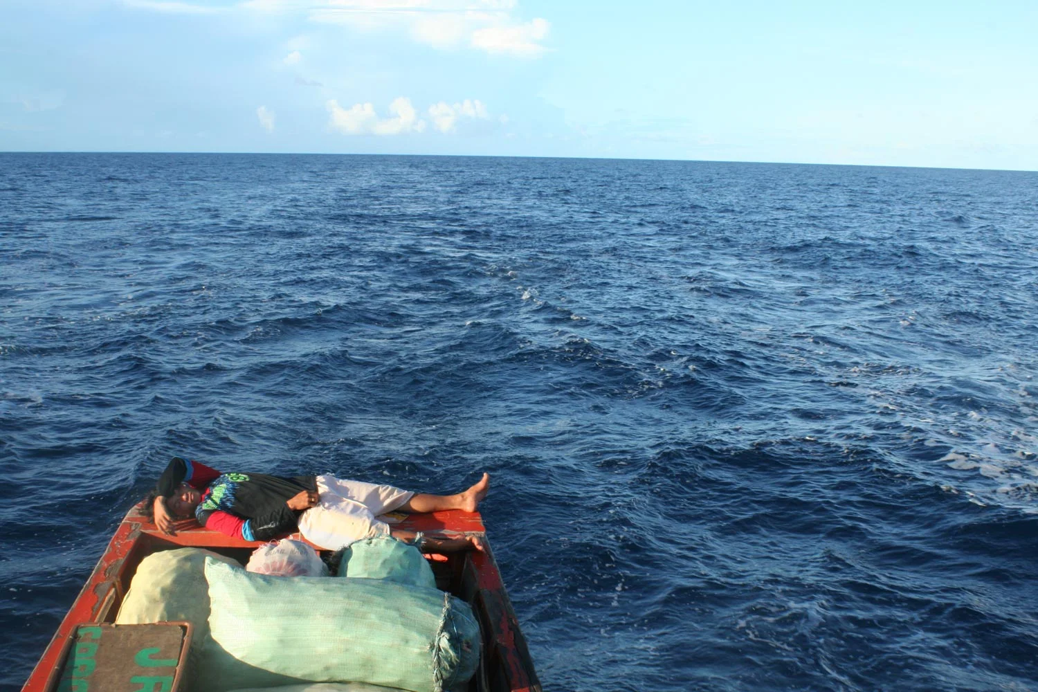 A trader takes a break from a day-long journey bringing sacks of rice from Mindoro to Palawan by boat. Many local economies in the Philippines, such as food production and trading, could be disrupted by climate change, as more extreme droughts or rainfall hit the islands. (Photo by Dorian Merina)