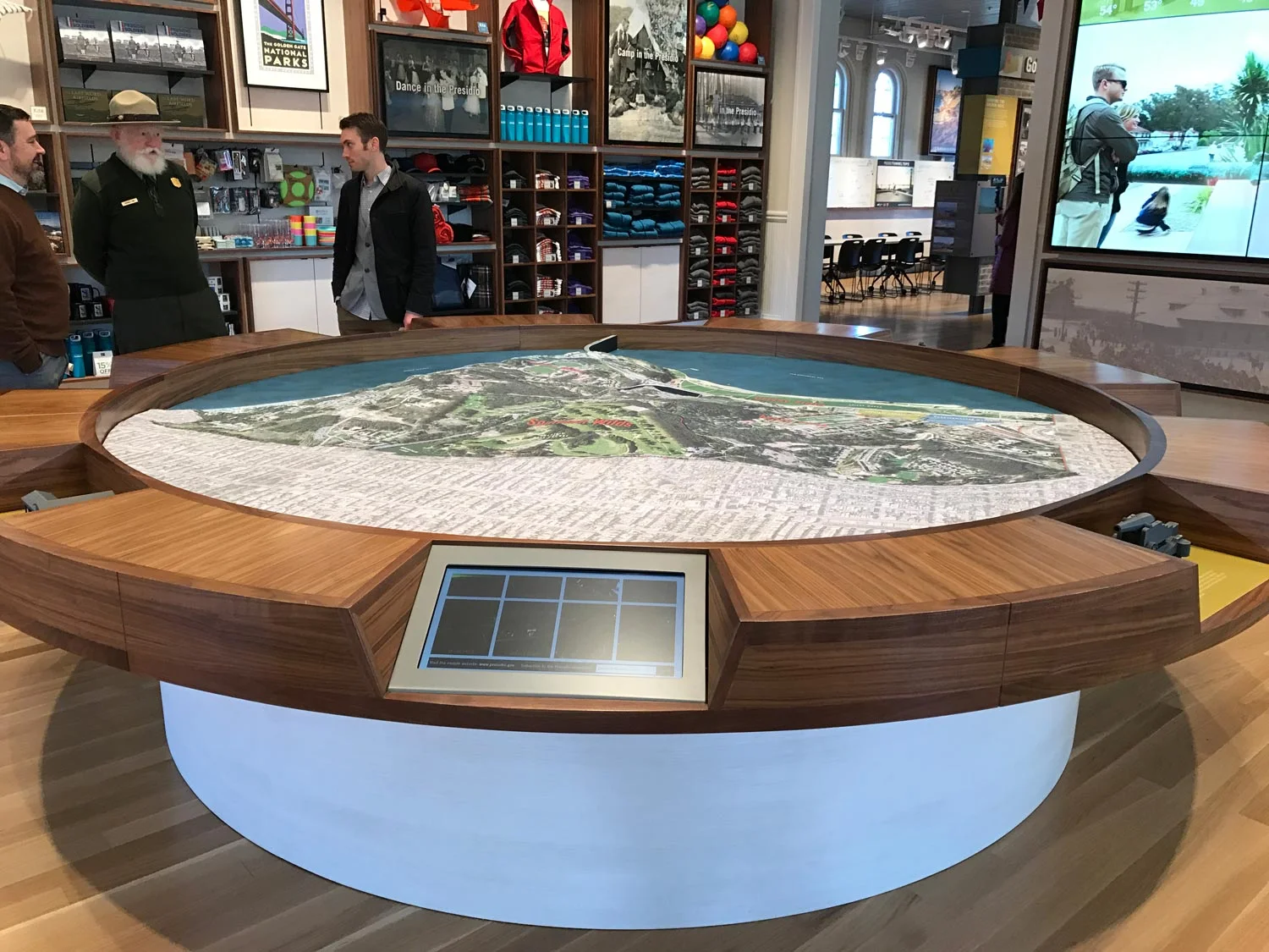 Large-scale Presidio model surrounded by touchscreen panels that help visitors select destinations to visit during their day in the park.
