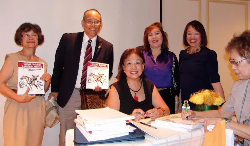 Book signing: Editor Pepi Nieva (seated center) with Mitzi Pickard (moderator and panel organizer), Ronie Nieva, and members of the Filipino American community.