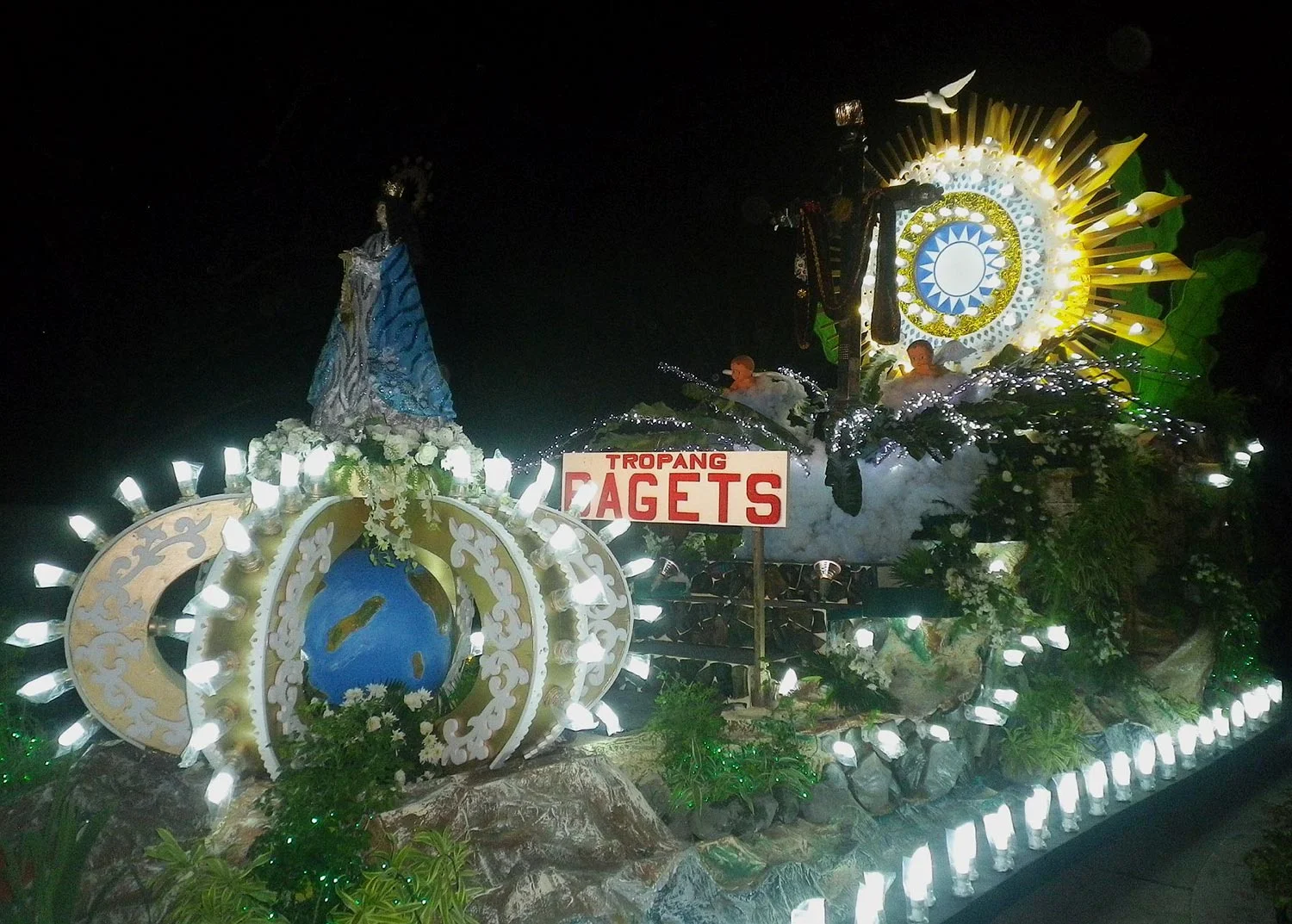 Ancient faith meets popular culture: the iconic symbol of Cupang's religious devotion is the 'Mahal na Poon', whose cross does not bear a crucified figure but a symbolic sun with a human visage. A youth civic group called Tropang Bagets borrowed thi…