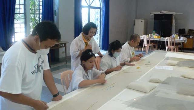 Members of ACES, a team Dalisay established in 2001, work on a Botong Francisco mural.