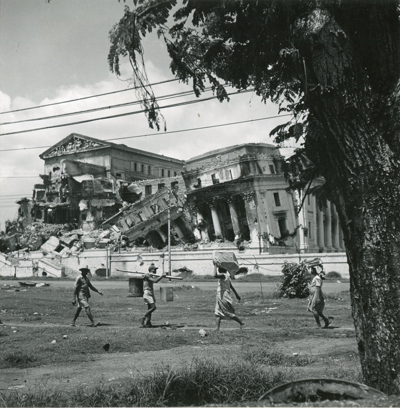 Life goes on as Filipinos walk in front of the ruins of the Philippine Legislature in May 1945. (National Archives)