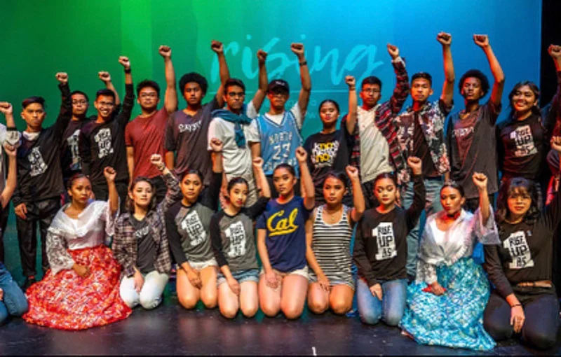 LMASP and “Us” History students get ready for the 2018 showcase titled “Rising.” They pose with a fierce look on their faces with fists in the air that refuse to back down. Photo by Doug Villalos.