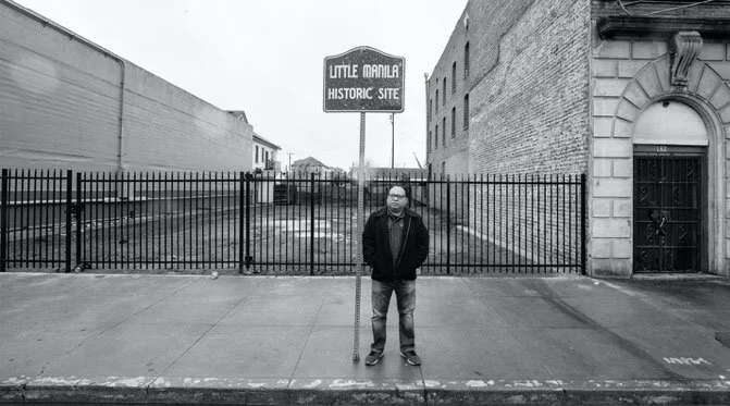 Dillon Delvo, co-founder &amp; executive director of Little Manila Rising, standing in front of a blank space in Little Manila. In 2020, the building where the Rizal Social Club once stood was demolished by the City due to its collapsing roof, which made it structurally unstable. (Photo by James Sobredo)