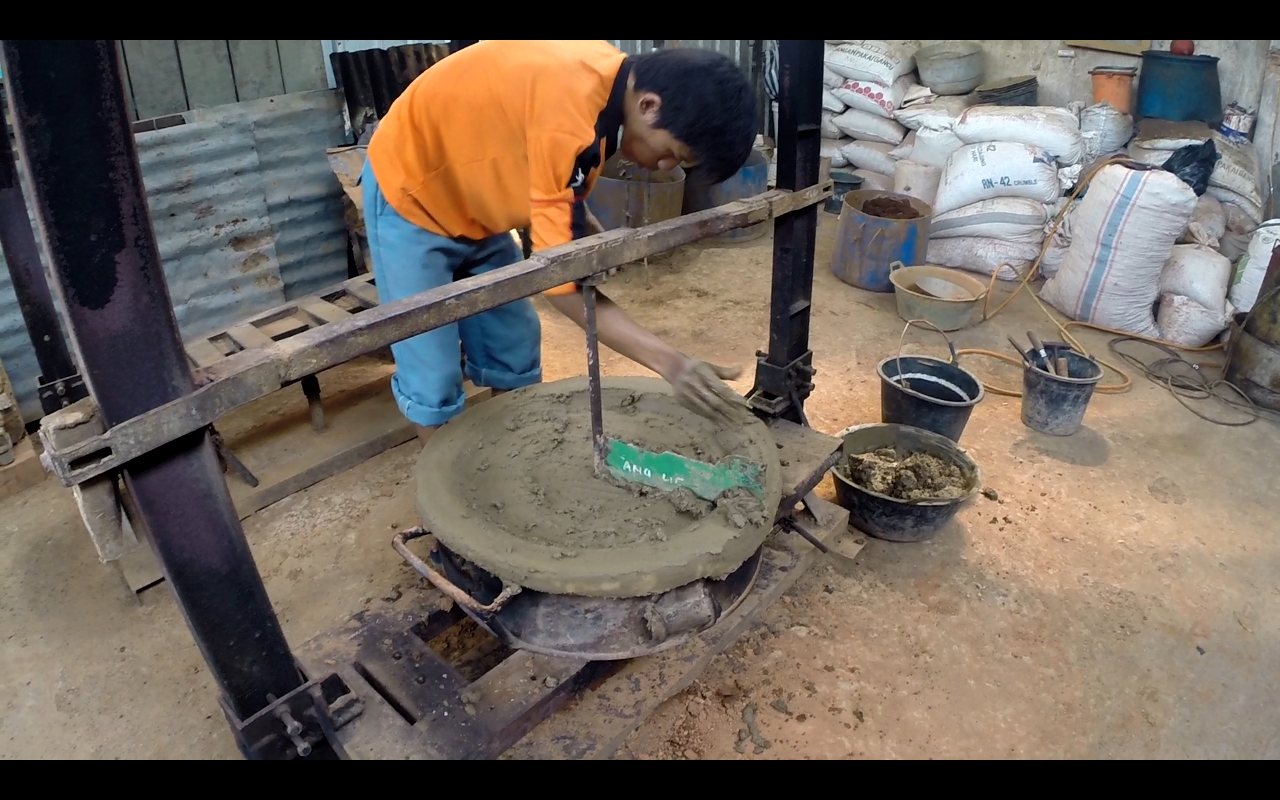 Carving the clay molds that would be used to make the woks.