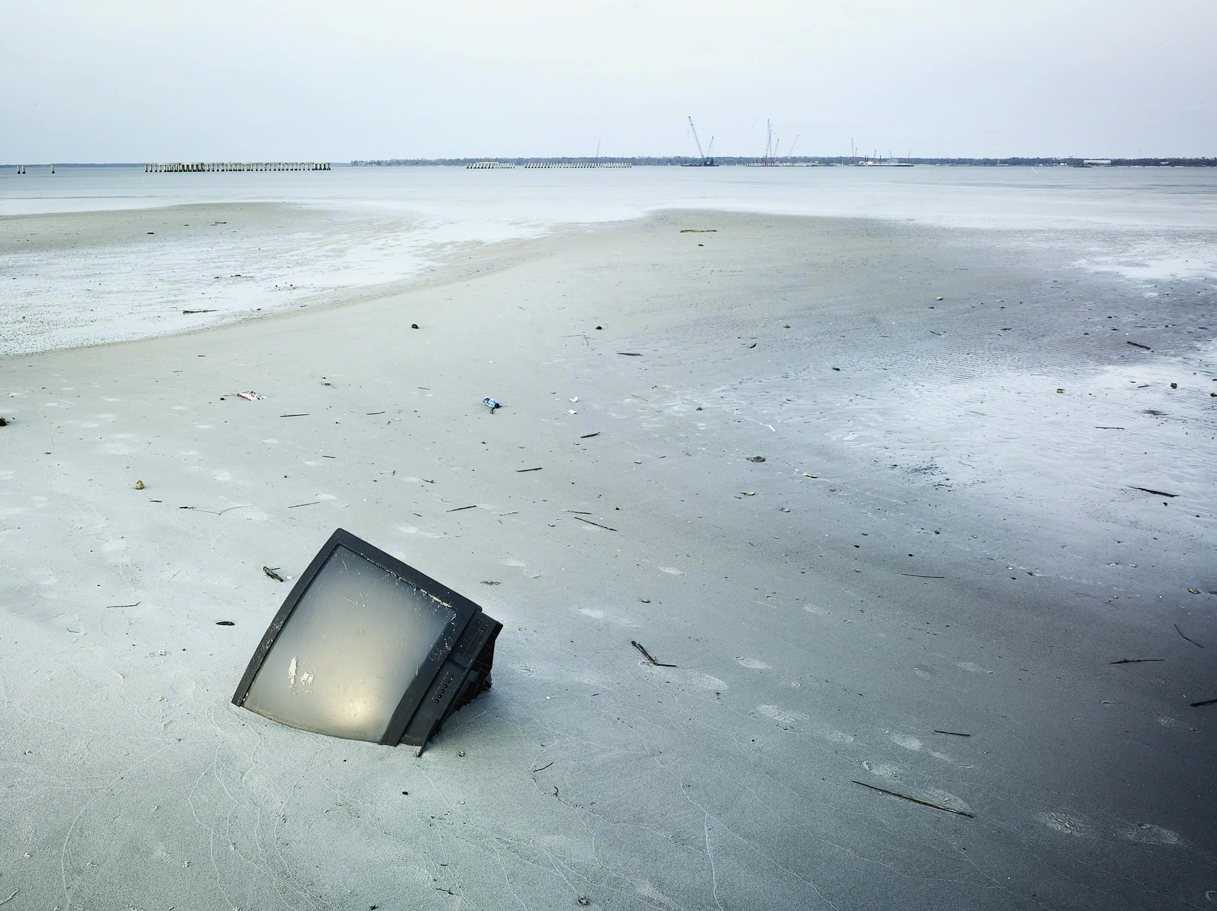 TV in the sand post Hurricane Katrina, Bay St. Louis, Mississippi. © Stephen Wilkes courtesy of Peter Fetterman Gallery.