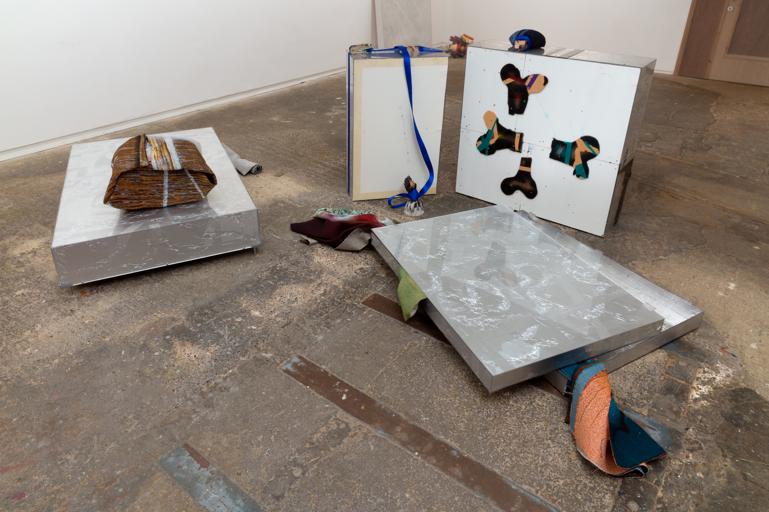 Understudies (2015). Acrylic, aluminium tape, chipboard, Jacquard tapestries, lavatory stall screen, MDF, paint, paper, paper tape, photographers' tape, ratchet strap, wooden bed parts. Courtesy Nigel Massey. Photograph: Peter White