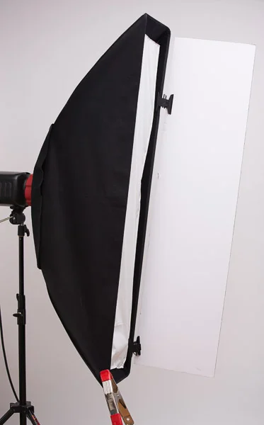Barn doors don't have to be restricted to only working with small lights and hard reflectors. I also use the Mulit-Clips and foamcore to create barn doors for my softboxes and strip ights to help control light from spilling into areas where I don't want it. Here I show a barn door solution for use with my Westcott strip box **. The spring clamp is there to balance the weight of the foamcore so the box doesn't spin in its speedring.