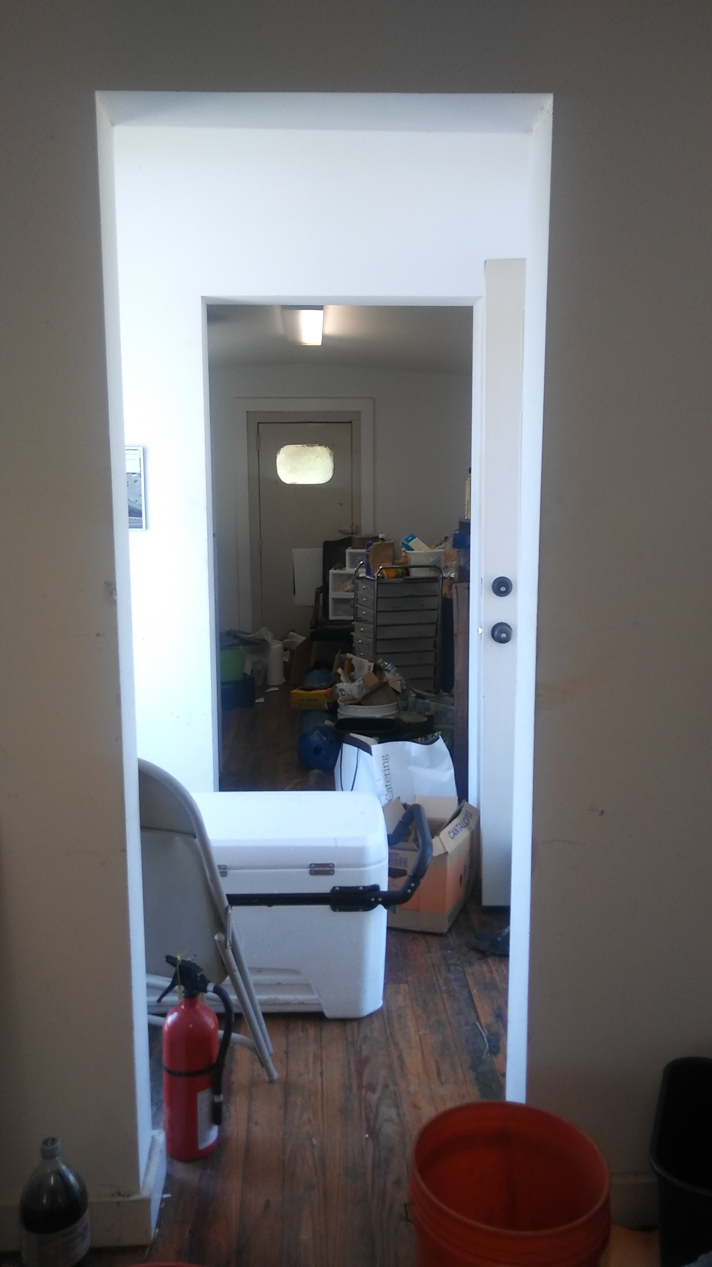 A cooler for produce storage, piles and piles of stuff, and a fire extinguisher. Safety first!