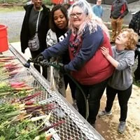 Michelle Glass, who co-manages the gardening program at the Therapeutic Recreation Center with Mr. William, helps participants wash their freshly harvested carrots to take back the the Center