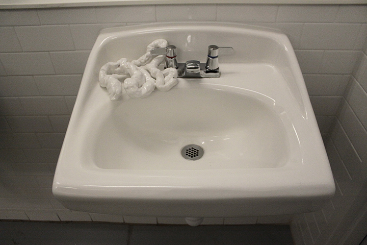   Porcelain intestines , 2013, porcelain mounted on restroom sink as part of “In Loo” exhibition, 6” x 9” x 7” 