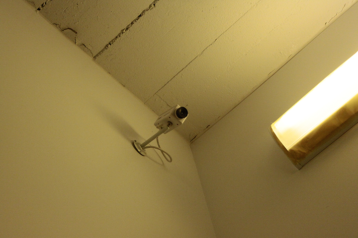  Surveillance camera and yellow tinted lights by Lexie Stoia  