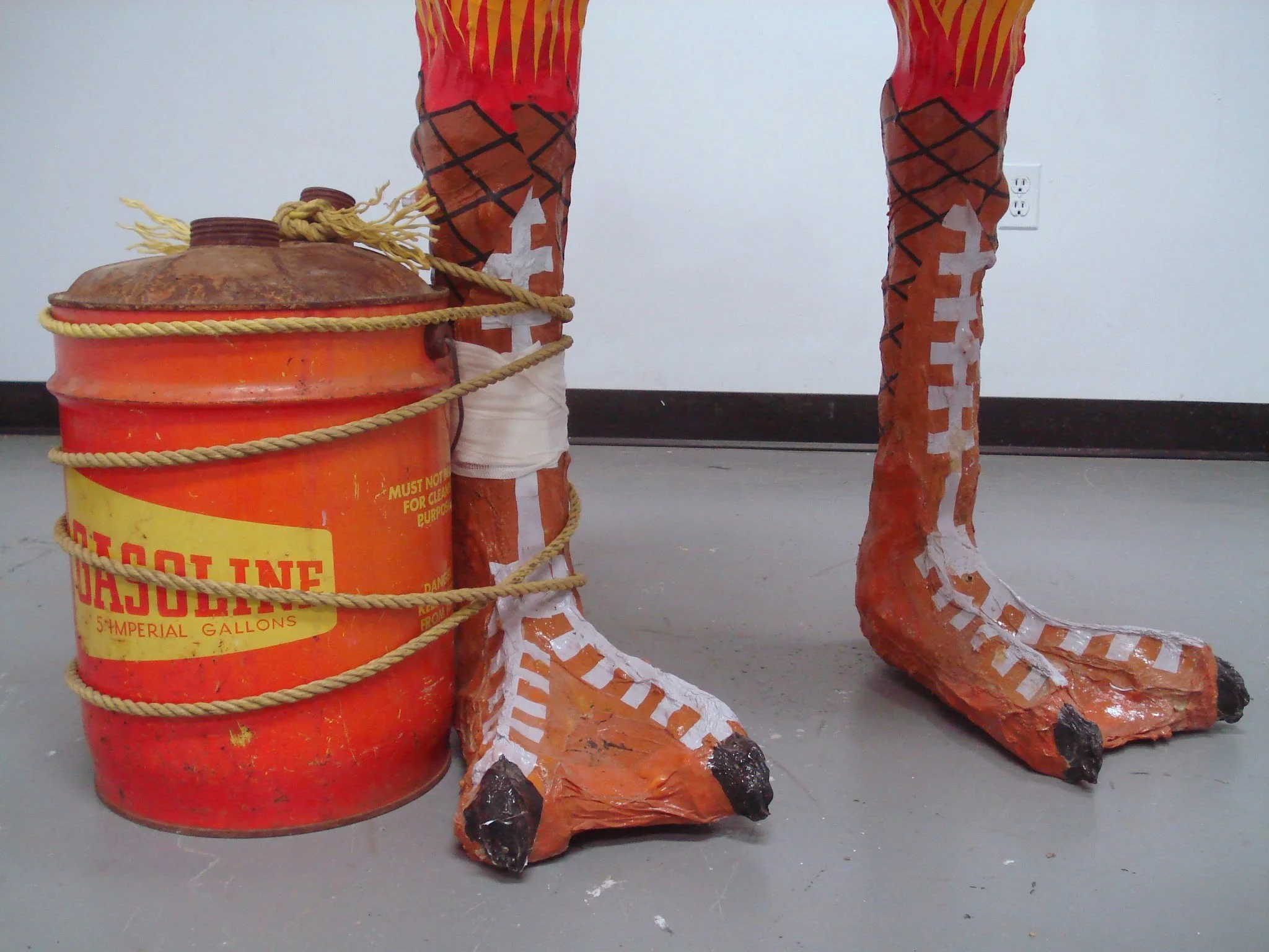  Due to the weight of the head, the sculpture was top heavy and wouldn’t stand up on its own. Inspired by the tree trunk supports carved around the legs of ancient marble statues, I tied a cartoonish gas can to its foot, as if it threatening to set i