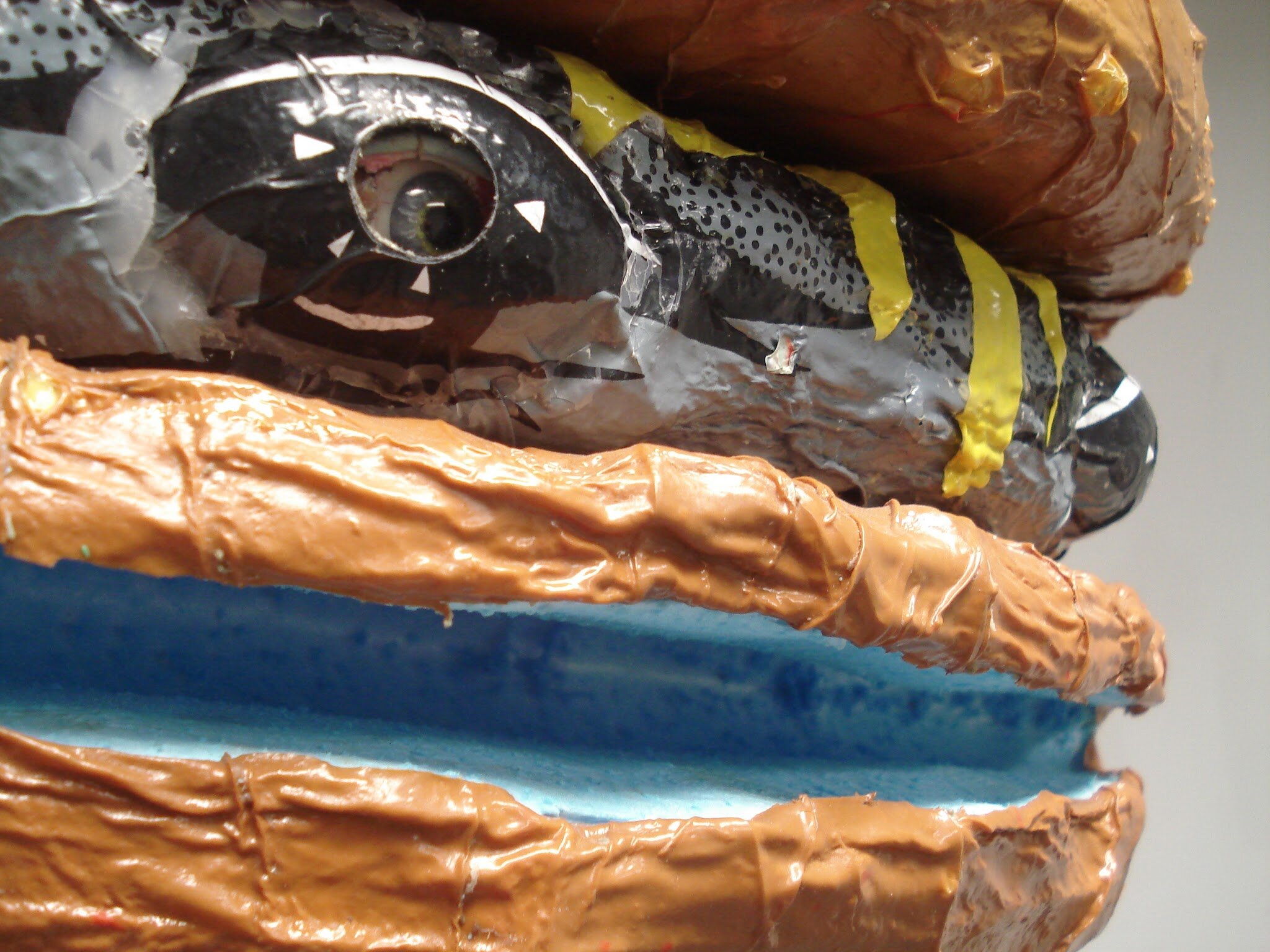  I used glass eyes for the shark’s eyes, peering through holes cut into a Silly Putty container. I placed them within the existing eyes of the shark shaped beach ball skin. 