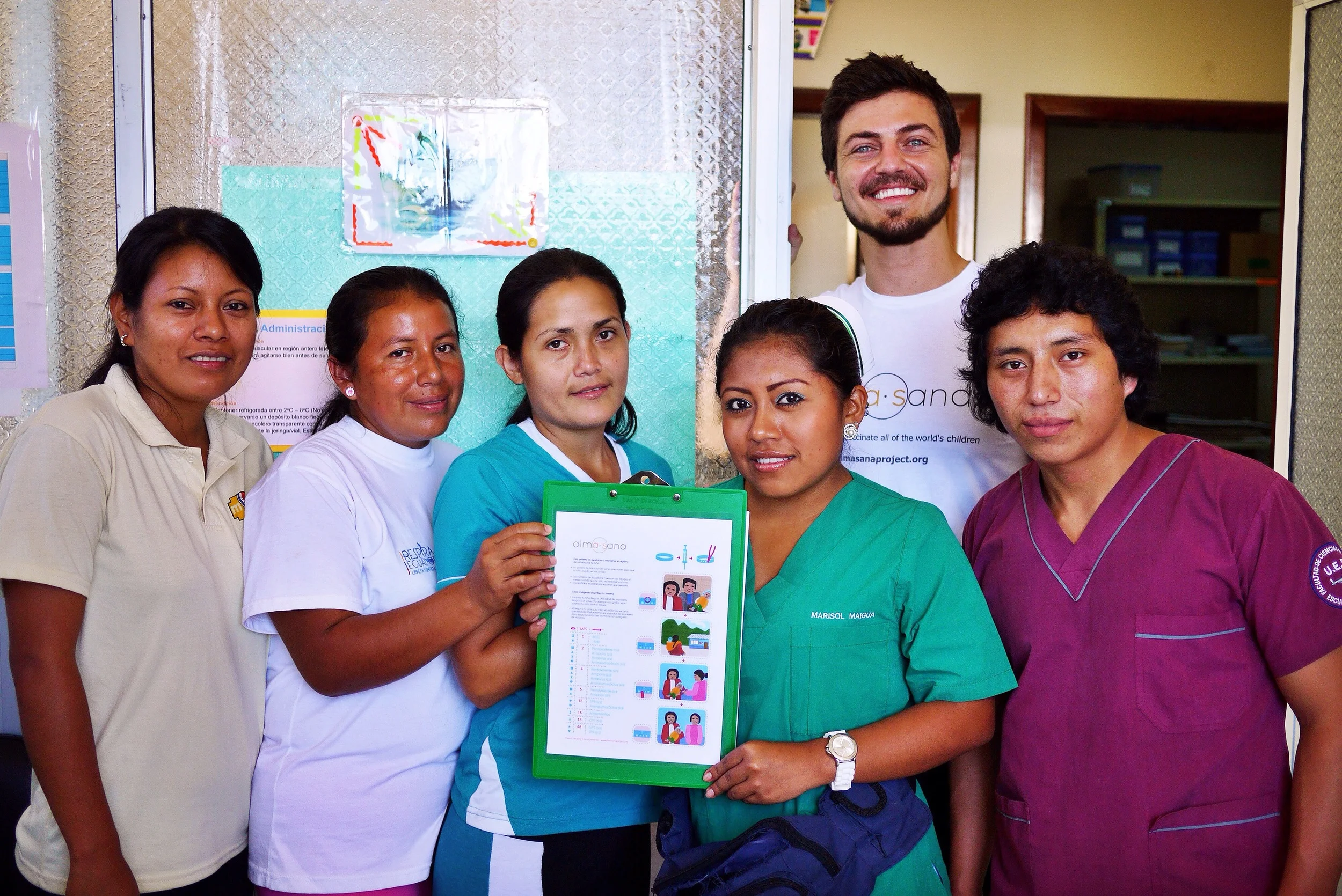 Alex Bozzette (in Alma Sana shirt), our Ecuador Project Coordinator, with the health center immunization nurses who also served as our study staff. Here they're presenting the locally adapted vaccine symbol guide for low-income moms. Photo taken: June 25, 2013. 