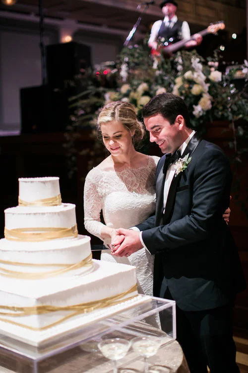 The newly wedded Browns cut their beautiful wedding cake at theit Schermerhon Symphony Center wedding reception in Nashville, TN. Wedding planning &amp; design by Big Events Wedding.