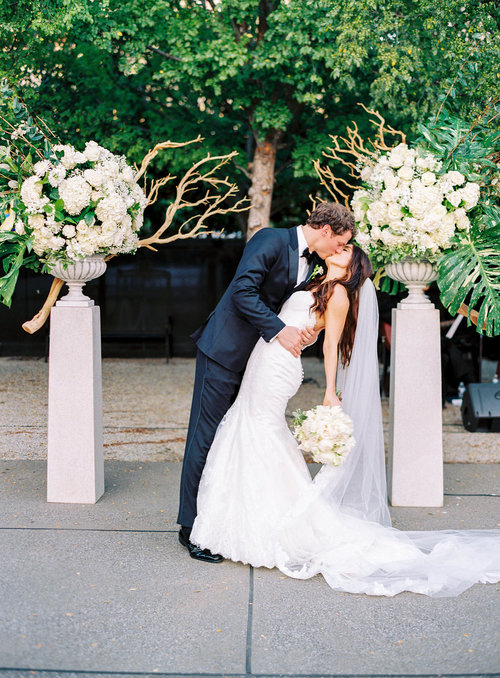The groom kissing his bride after their wedding at the Frist Center for the Visual Arts in downtown Nashville, TN. Wedding planning &amp; design by Big Events Wedding.