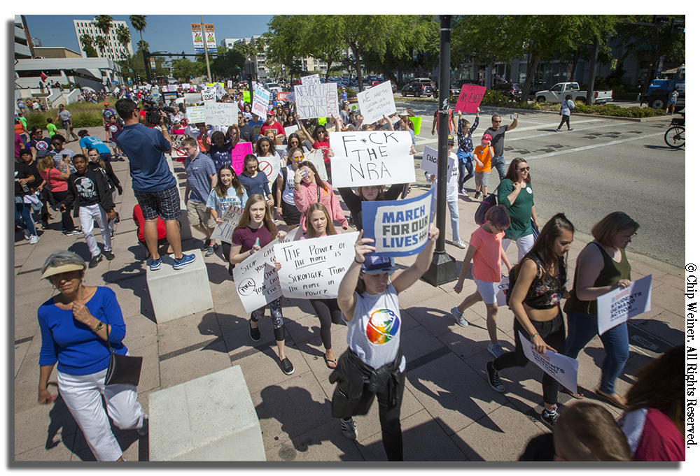 Demonstrators march beside Ashley Street in downtown Tampa