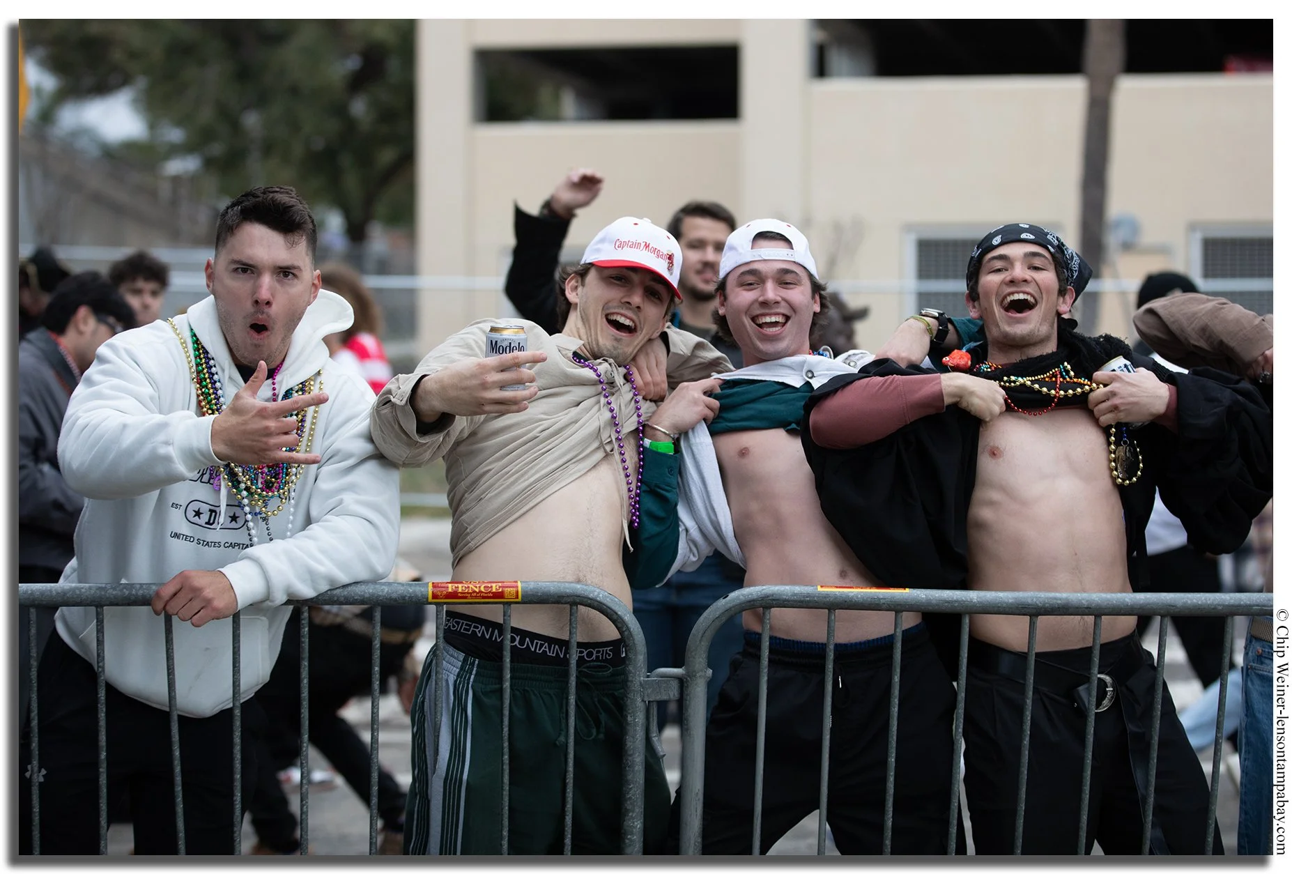 Gasparilla parade revelers wearing minimal costumes despite cold weather, hoping to earn beads from passing floats in Tampa.