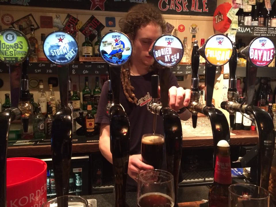 I asked the local girl at my hostel where I should go to avoid the tourist and she sent me under the Spanish arch over the city bridge to BierHaus bar. Where I was greatly pleased. Full of local Irish great craft beer and the most amazing music. A place hipsters would die for but this place wasn't made to look hip it was hip. I had the greatest chocolate stout by "Galway bay Brewery" made right in Galway I tried flight and I was very happy with them all but the red ale. I also had the Galway hooker. Honestly at this point in my trip to Ireland I was just glad to drink something but a cider beer. I knew the Irish loved dark beer but I didn't know they where so in love with cider. I sipped my beer while I got lost in the music I was compleatly relaxed and enjoying the atmosphere of the place. after the band played I spoke to them and asked them there band name, they then told me they wasn't a band that they all had belonged to other bands but they just drop in and play here together for fun. my mind was blown i was ready to throw money at them and become the excited new owner of there cd. it was traditional yet hip and it started my obsession I now have with folk music. I left BierHaus and poped in Monroe’s Tavern where I grabbed a sliced of very tasty pizza siped another beer and watched some more live music. after my pizza I mosed back across the bridge back to my hostel where I sleep great and the next morning I woke up ate with some others that stayed at the hostels. This led to a very interesting experience one that will stick with me forever. I kid you not all this really happened to me. most the people in the hostel was young except this one guy, this guy with deep navy eyes that looked like pool of water that never ended, deep creases in his face and messy thin grey hair his skin was thick and tough and his hands was covered in black tar. This man opened up to me on a whole another level, he had held it in for so long he was busting at the seems to tell his story. It all stared when I told him I one of the reasons I came to Ireland was because I thought I was Irish, I told him my last name was Kirkpatrick then HE told me, my whole history of my heritage that im Scottish. He told my name translated to "church of patrick" and explained to me that Kentucky is full of rich Irish culture because Daniel Boone and Davy Crockett was Irish they settled in Kentucky because it reminded them of Ireland, its how we have bluegrass music and other Irish traditions including horse racing he spoke as if he was Davy Crockett him self he knew so much as if he had explored Kentucky him self. This is not the crazy part heres where it get real good. After this history lesson this man began to tell me how when he was young he had fell in love with an asian dancer he had met the way he spoke about this women you could tell he was in love with this girl as much as the day he met her, the only place I've ever heard a man talk about a women like this was in corny romance movies. I could feel his heart ache for this women and although this story was becoming highly inappropriate I was intrigued and could not wait to see where it was going. he really drug out the story much like I am now ha but then he finally dropped it on me he then explained how he was stuck in a love triangle with this women and that she was married and she had convinced him to murder her husband and HE DID! he admitted it to me and as he told it he was not proud, he barely could get it out his voice was riddled with pain and each word was as heavy as a stone wall he had to really pushed to get it out. not exactly you regular breakfast topic. the story went on and as you can imagine it did not have a happy ending the women ran off told him that if they was seen together they would be caught and that they had to go there separate ways but would meet up later in life and live happy ever after. what I took from the story was that she never intended to marry him or love him that she was only manipulating him to get rid of her husband take both there money and run off. He honestly believed he would meet up with her one day and they would love each other although they have had no contact at all. He went looking for her at the Beijing olympics but he didn't find her well duh I imagine thats a huge event and Im not sure if she would be performing or what but He thought she would be there because when he told me this part of the story he almost cried. I later learned from a local that he was what they call "travelers" or what american's call Gypsies' they told me most work in freelance jobs like construction and are always on the move. traveler in Ireland are frowned there seen as uneducated scam artist, lier and thief's. I couldn't help but feel sorry for this traveler because he had been lied to, he had been scammed and in fact he had his heart had been stolen. I knew this women had manipulated him to get what she wanted and tossed him a side. Im not saying this excuses him from murder and although he never went to prison he had paid from what he had done, his guilt has torn him apart and he had lost the love of his life a free mans true prison. 