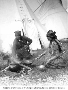 two native american women cooking over a fire in front of a teepee, 1929-1932 ~