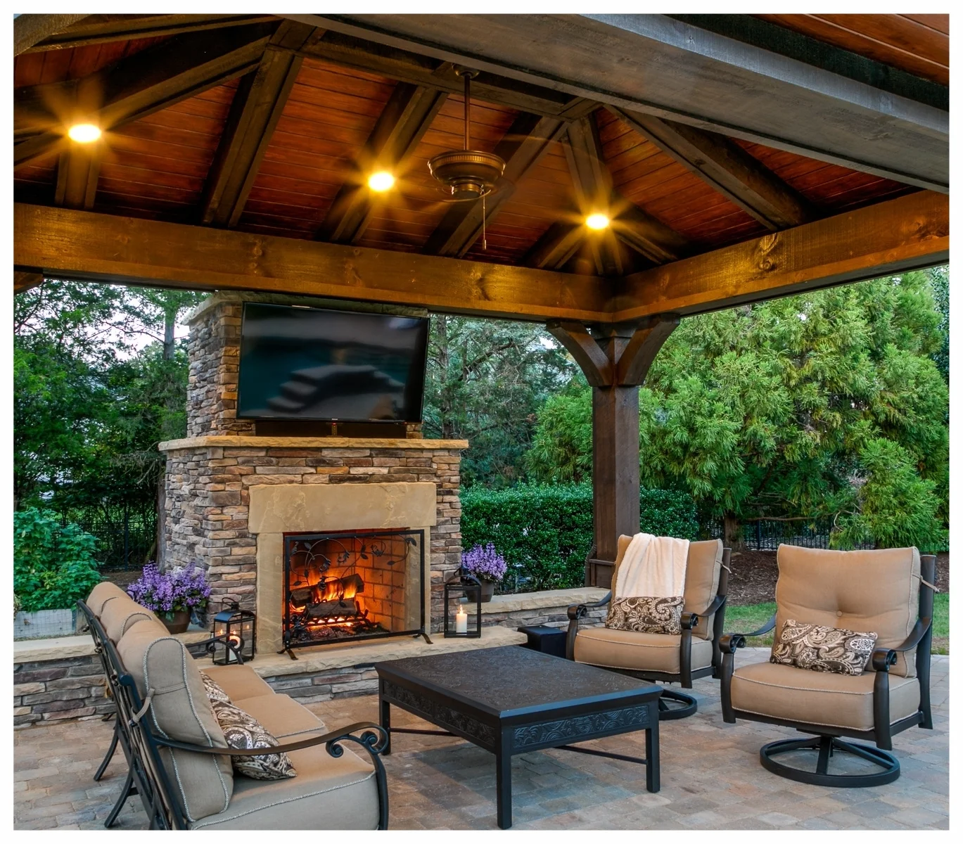 A custom craftsman cabana with stone fireplace and seat wall, designed and built by the Outdoor Artisan team as an addition to our client’s existing pool area.