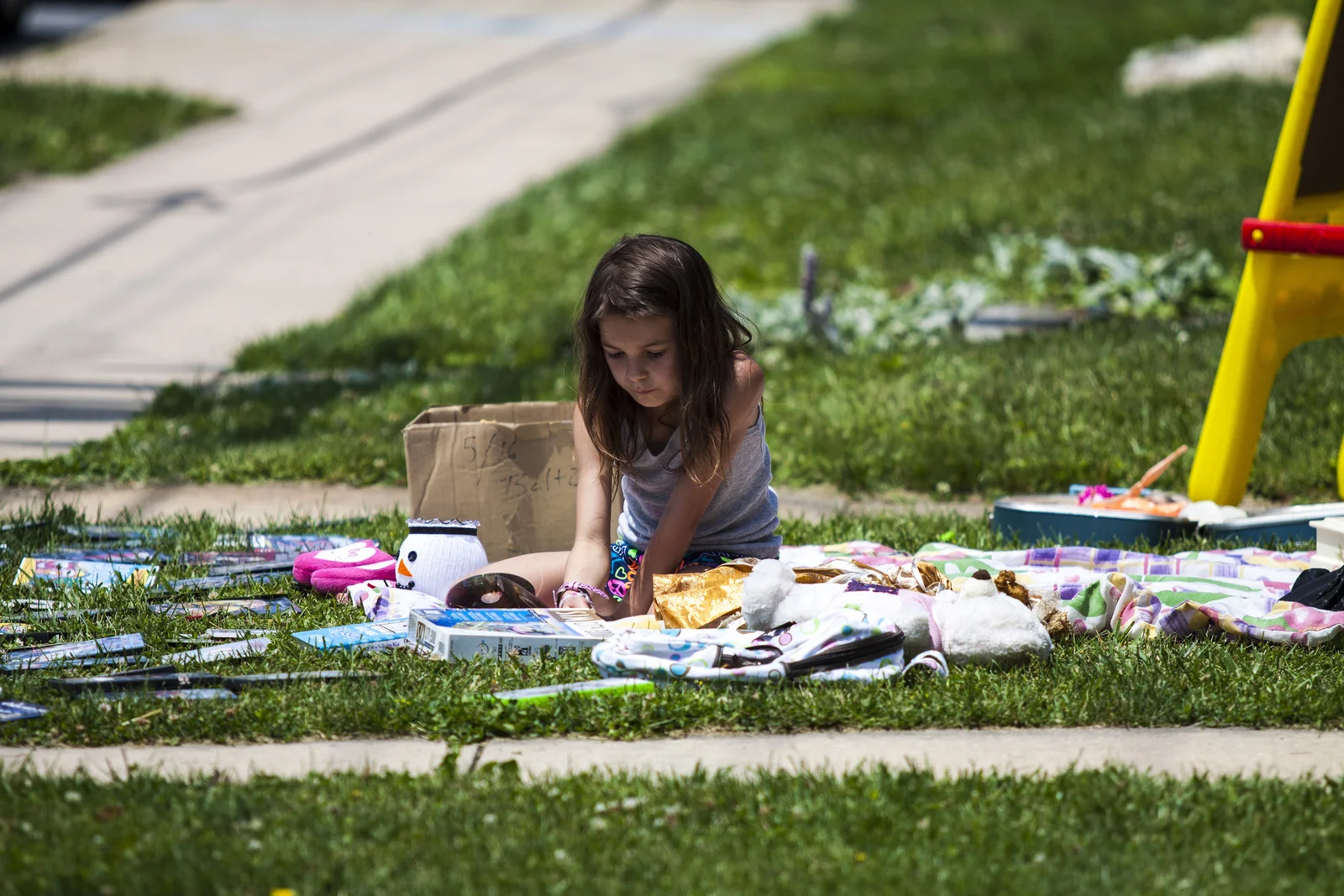 A child plays on a blanket in a sea of DVD's.