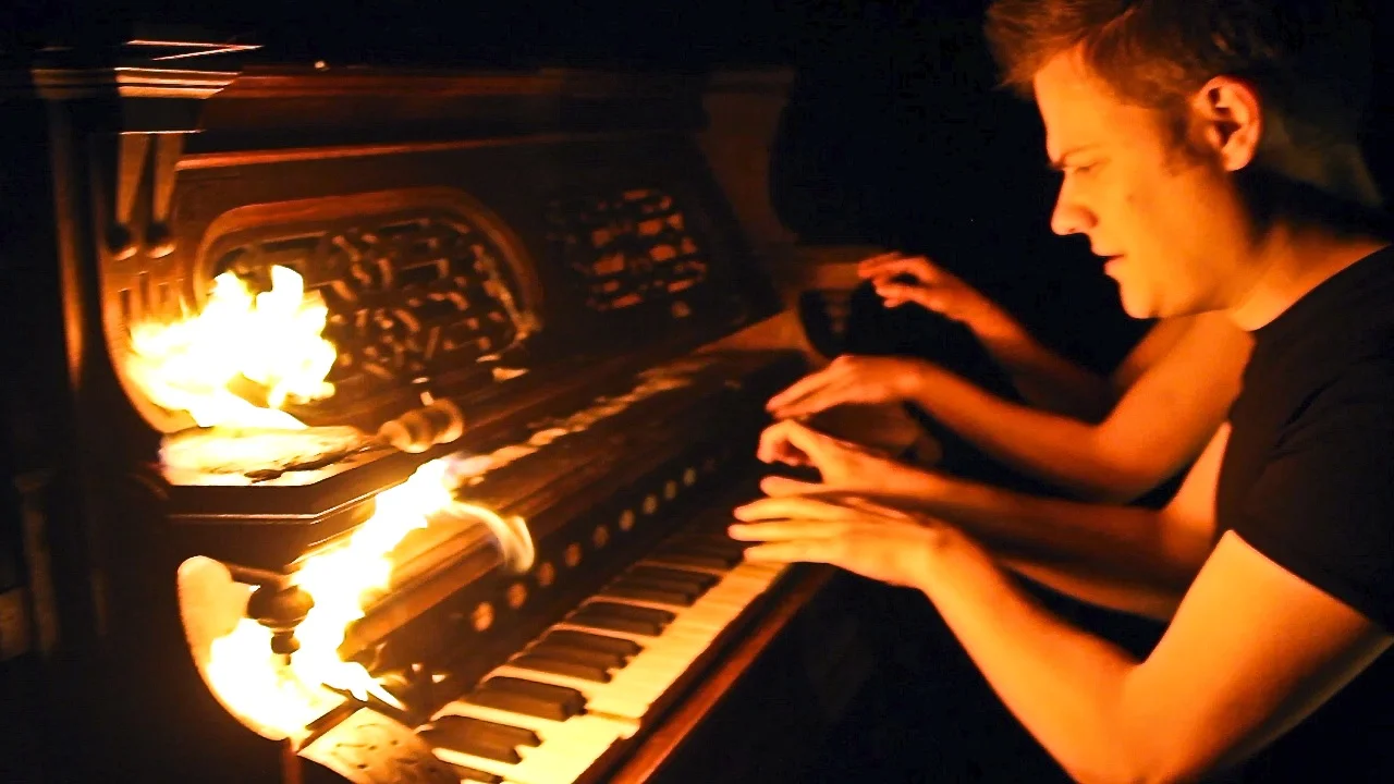 Anderson and Roe playing piano with fire.jpg