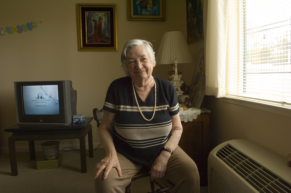 Marylou Peacock with a few of her paintings behind her.