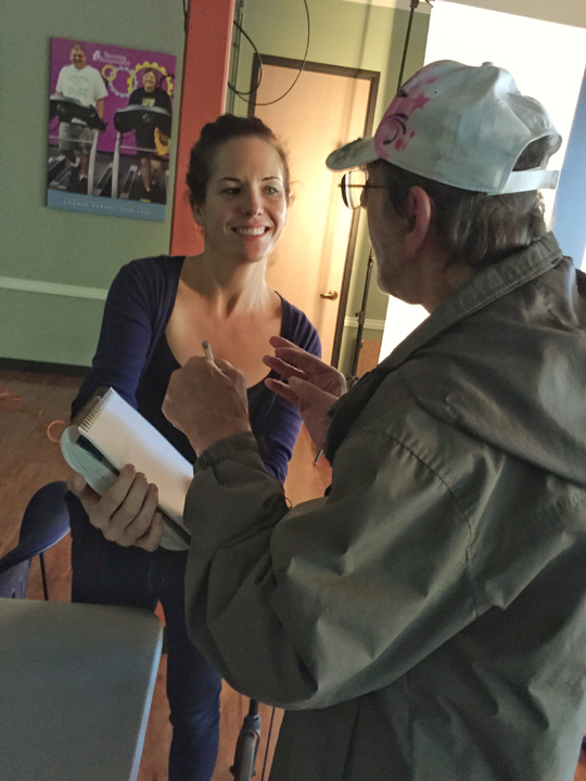 Meredith asking Fred to sign in the book.