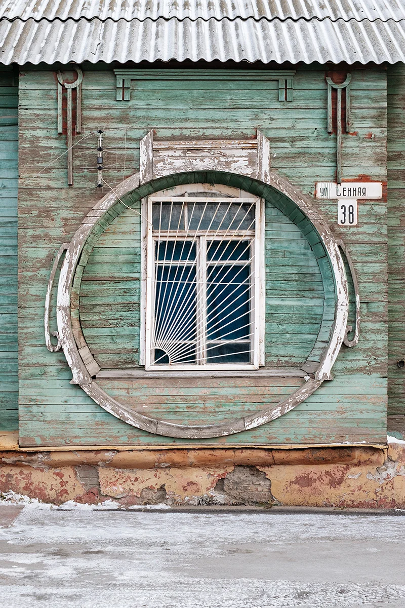 A wooden house with a decorated window, typical of the region.