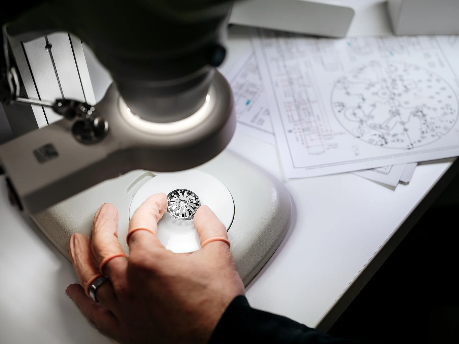 Inspecting a component, the platinum sector of the winding rotor of the Horological Machine No.7 - Aquapod at the MB&F atelier.