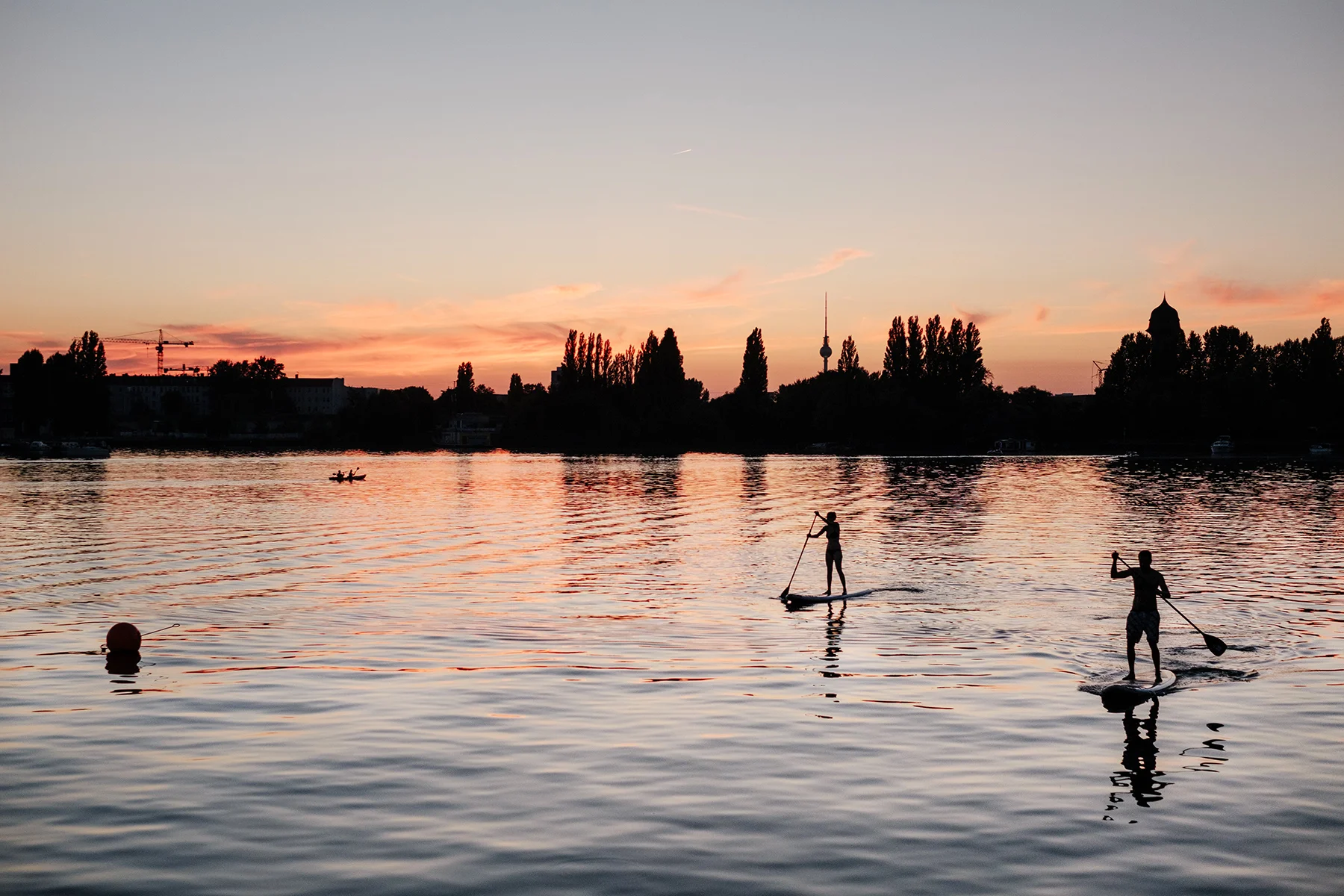 Paddle boarders and a kayaker in Rummelsburger See near Ostkreuz.