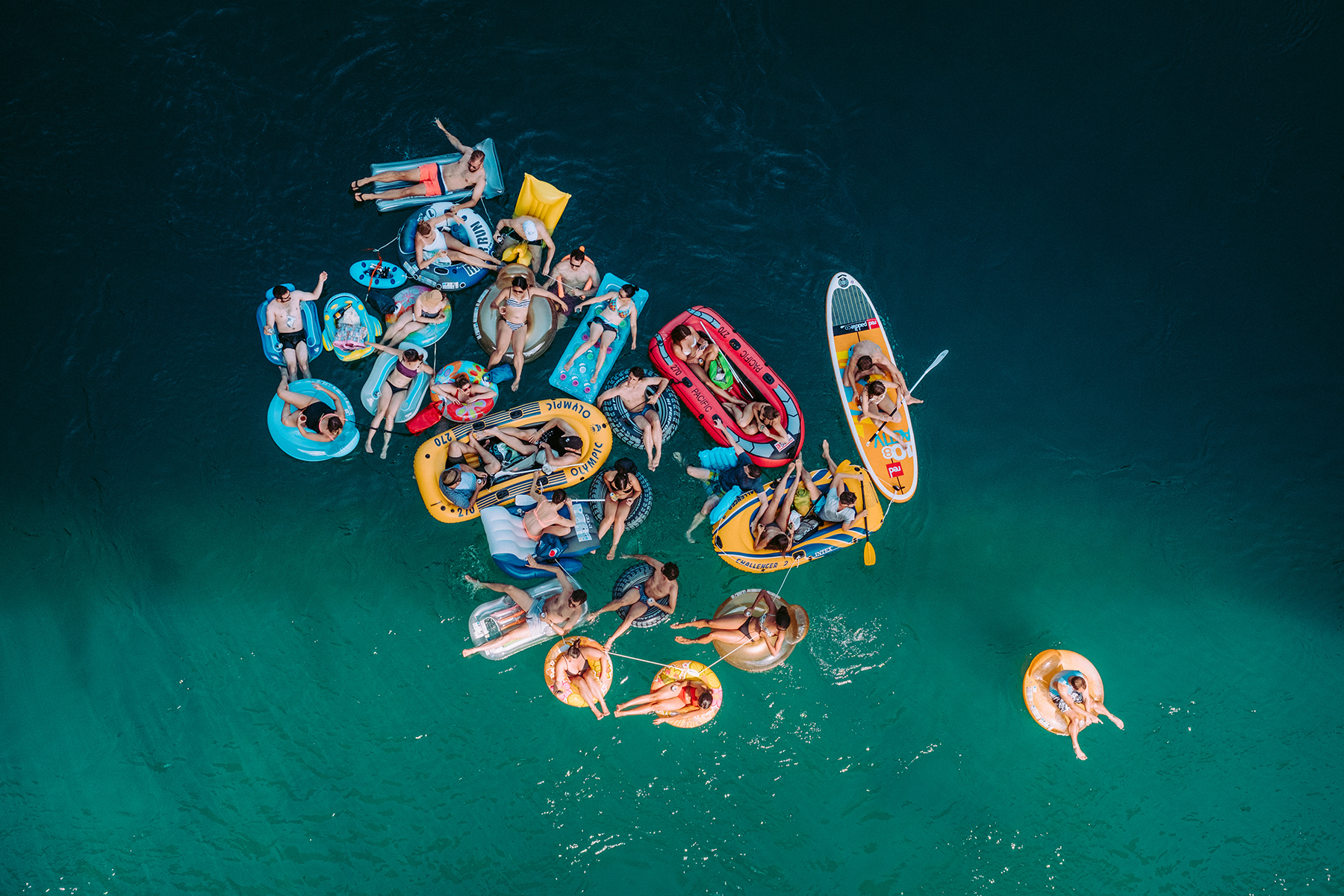 Summer at Pointe de la Jonction, twenty-nine people on various floating devices on the Rhône river.
