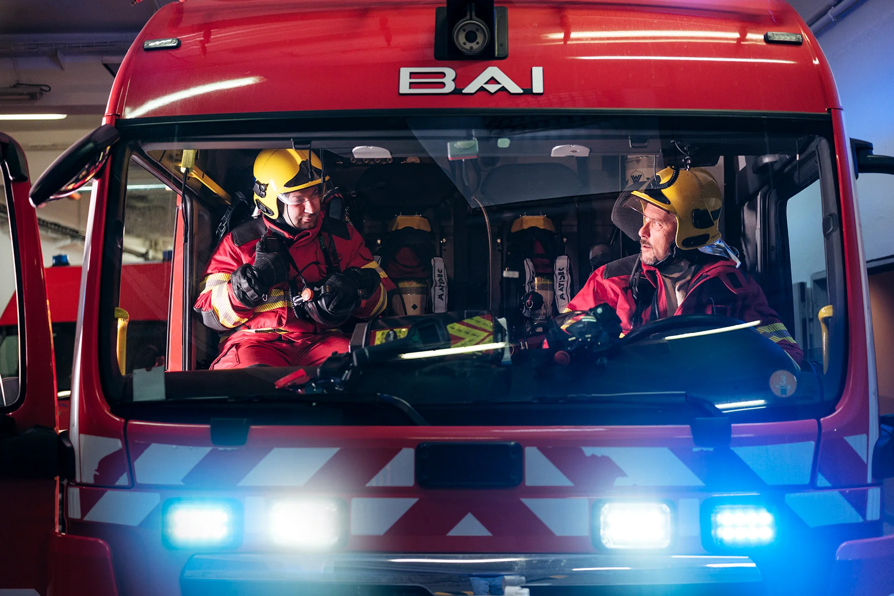 Alex Paonna (left) and Rudy Fassin (right), direct response crew (professional firefighters) inside a Proteus truck, in the firefighter hangar on the French side.