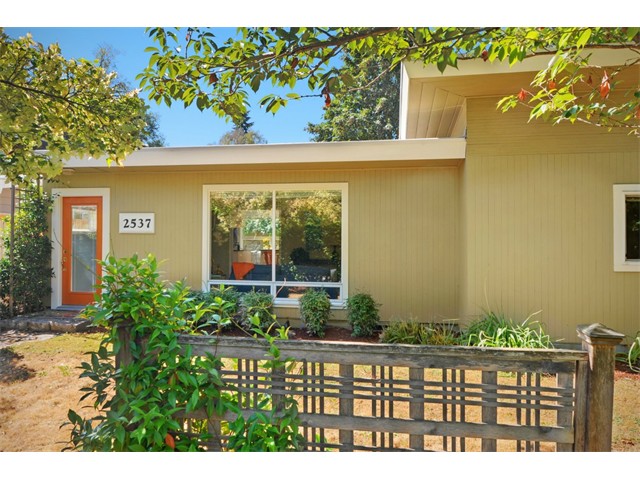 Hip mid-century modern in Wedgwood. Shed roof, open & bright floor plan & great lines! Updated kitchen w/ spacious dining area all flows into large living room w/ picture windows & wood burning fireplace. Two generous bedrooms and refreshed bathroom w/ skylight. Rare, 2-car garage down long drive provides tons of storage and parking. Small shop space off garage as well as a 3rd non-conforming bedroom could be perfect home office or guest room. Property on dead-end street is private and secluded.