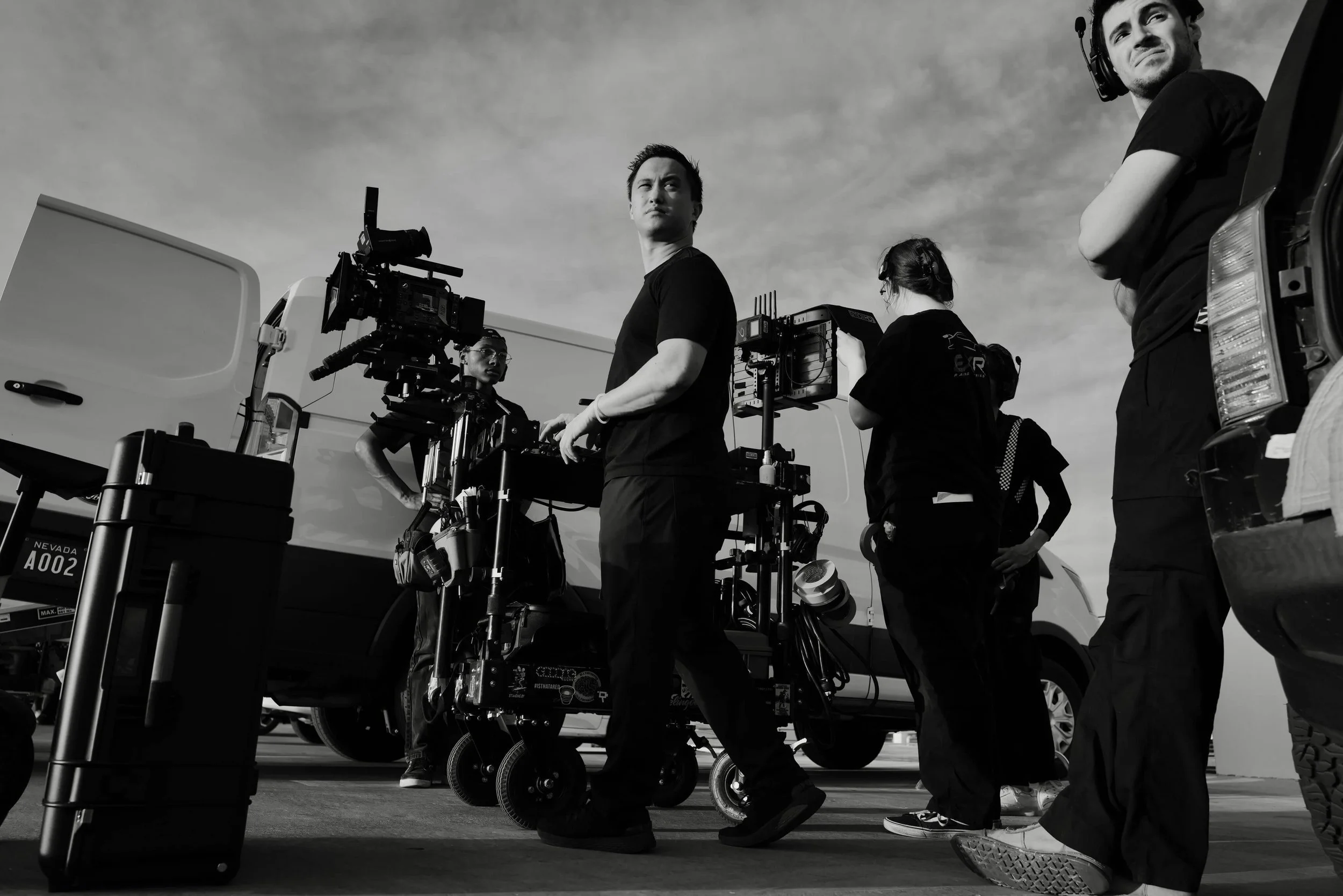 Cinematographer stands in front of production cart on a commercial set.