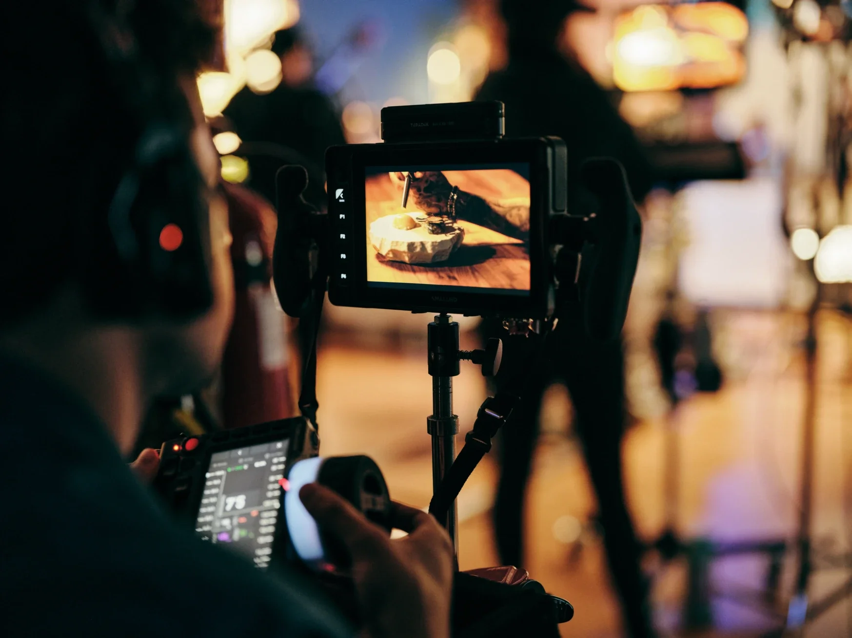 A camera assistant looks at a SmallHD Ultra 7 field monitor during a shot.