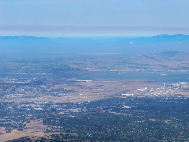Looking through hazy skies. Sacramento River at the Carquinez Strait passing below the Carquinez and Alfred Zampa Bridges before heading to the San Francisco Bay.
